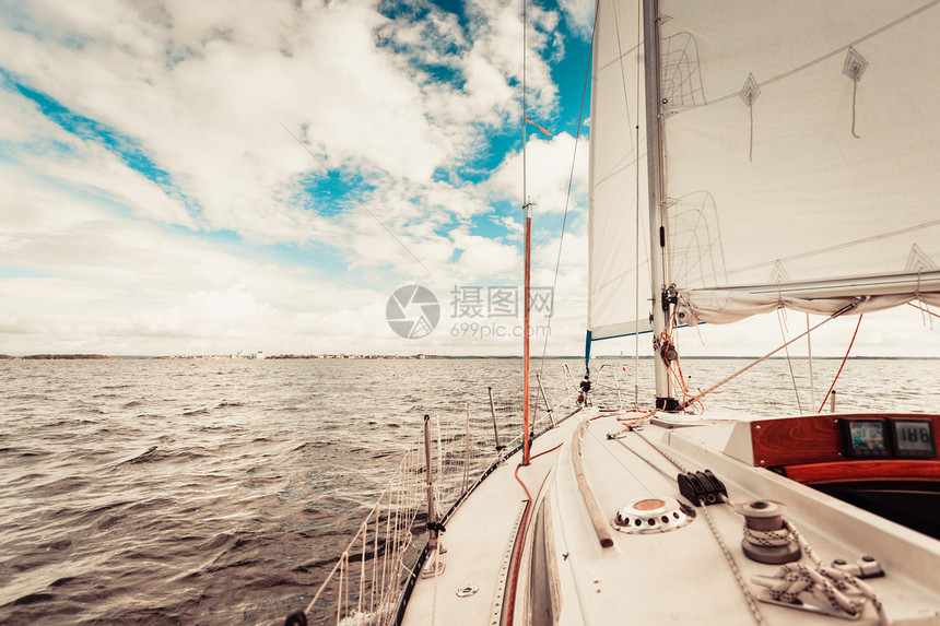 在阳光明媚的夏季天气中乘帆船在平静的蓝色海水上游乘帆船图片