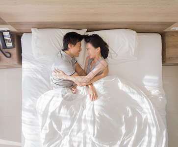 相爱的夫妻清晨在床上拥抱图片