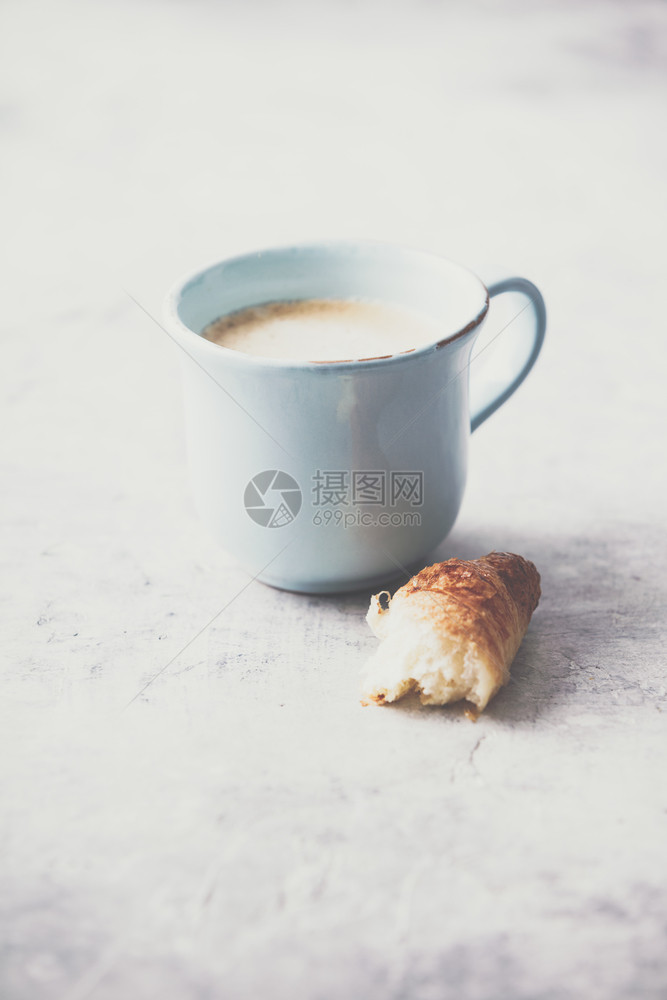 上午咖啡羊角面包和以浅灰底色背景的春郁金花早餐概念图片
