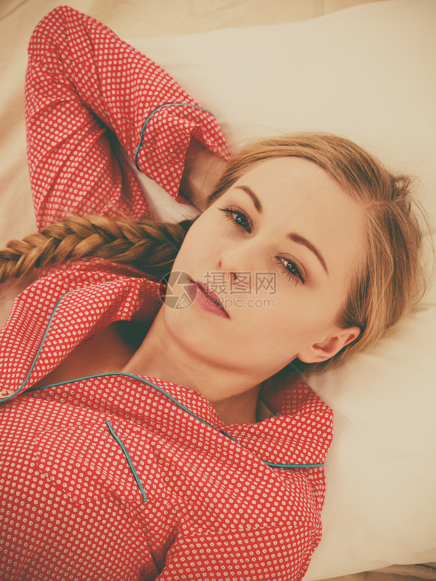 女孩在床上滚懒惰的年轻女士穿着睡衣在枕头上早不能起床图片