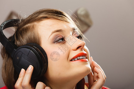 技术音乐和幸福概念在耳机中听音乐的笑少女图片