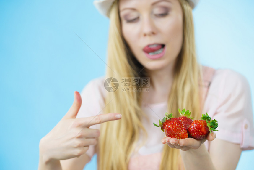 青春女子露出新鲜草莓水果用蓝唇舔嘴健康饮食女孩露出新鲜草莓图片