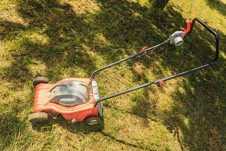 园艺服务旧割草机在后院绿阳光明媚的日间用割草机修剪场旧割机图片