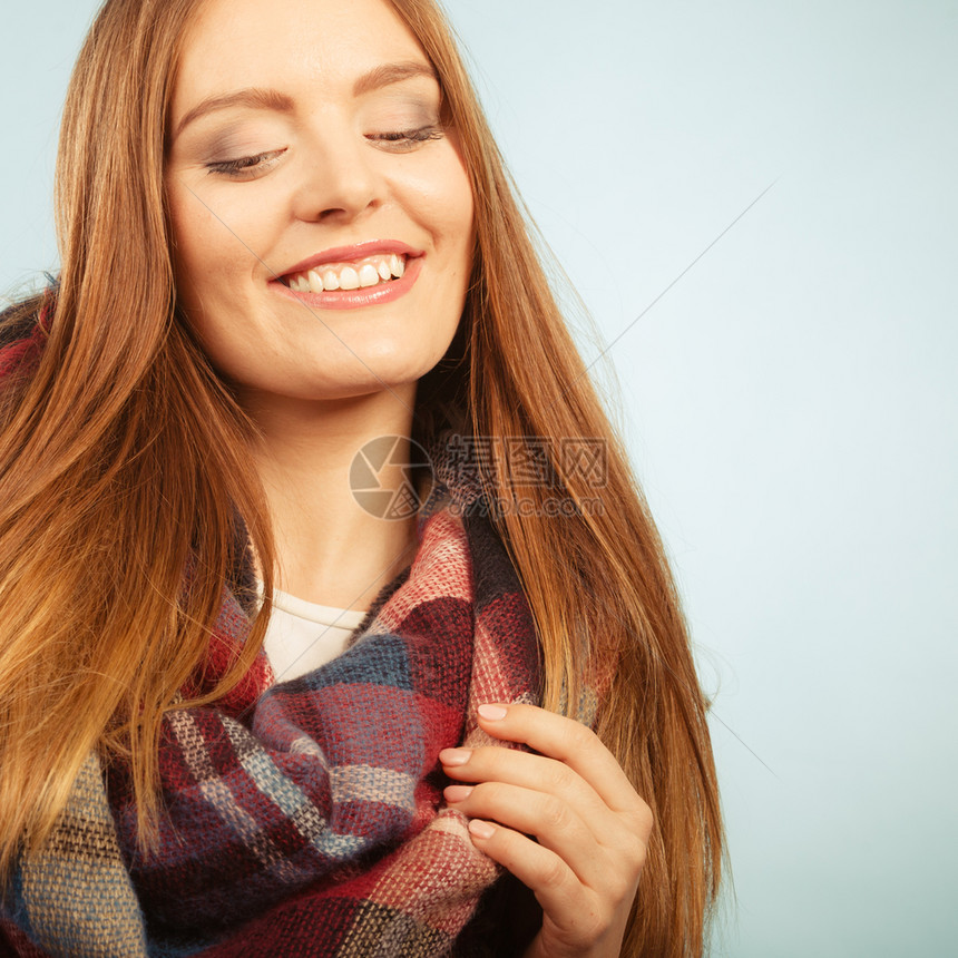 穿着暖秋衣羊毛的年轻长发女子穿着蓝色围巾羊毛衣的妇女穿着温暖秋日服装穿着羊毛衣的年轻长发女郎穿着温暖秋日服图片