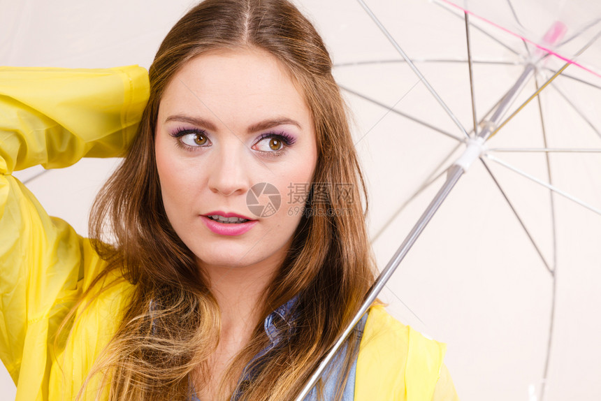 身着防水的黄大衣有透明伞式保护的女时装雨衣少气象学预报和天气季节概念身着防水大衣的妇女则身着雨伞式保护图片