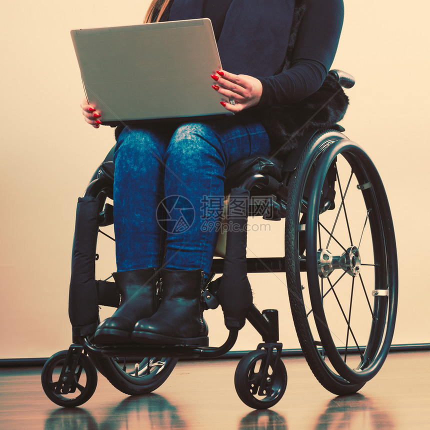 技术和移动设备使用膝上型计算机的残疾女孩轮椅上的年轻女商业工人使用轮椅上的膝型计算机残疾妇女图片