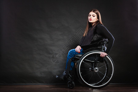 坐在轮椅工作室的残疾女孩被黑击中背景图片