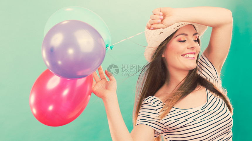 可爱的笑脸女孩玩多彩的气球年轻可爱的快乐女人在夏天玩得开心图片