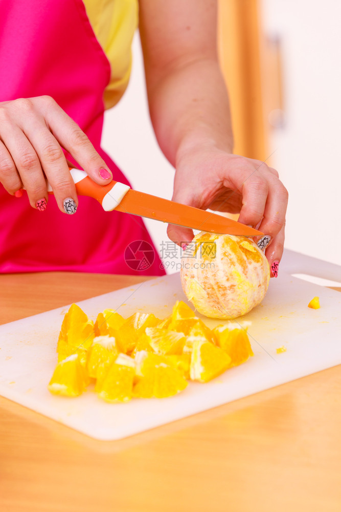 家中厨房的年轻女家庭主妇在切菜板上开新鲜的橙子水果用于沙拉或多汁健康饮食烹饪生品饮和人的概念图片