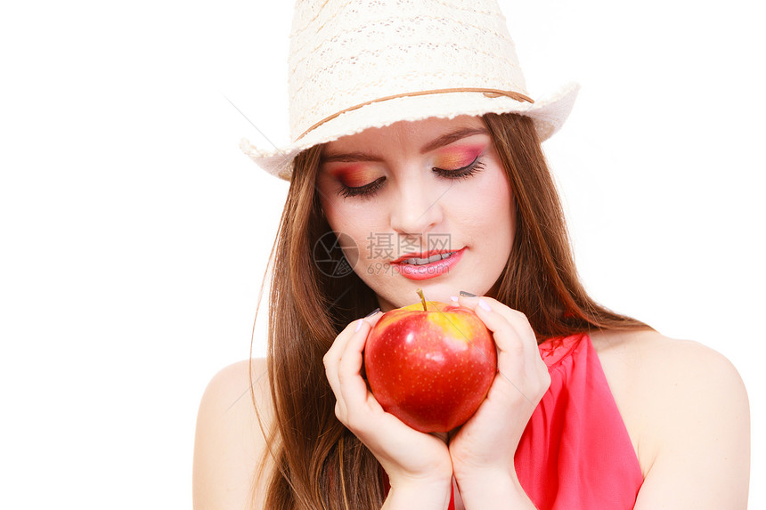 穿着暑假帽子的迷人女孩长发丰富多彩的假盛着大红苹果水健康饮食素和人的概念图片