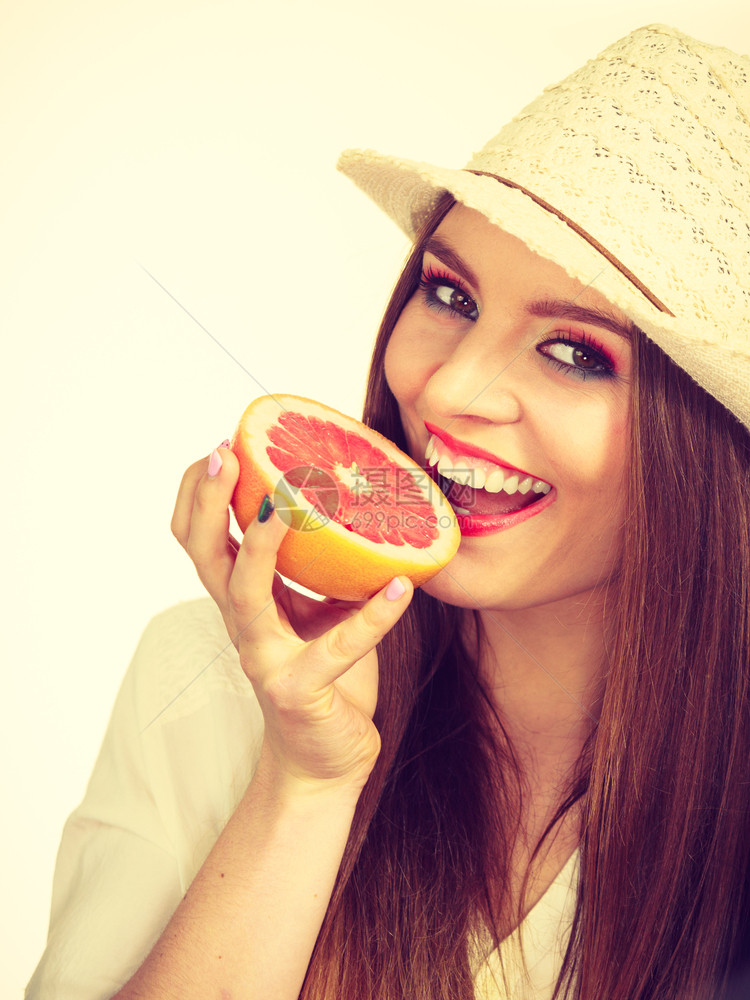 具有吸引力的长发女子美多彩的双眼装饰着一半的葡萄果柑橘水在手健康饮食品暑假乐趣概念持有一半的葡萄果柑橘在手图片