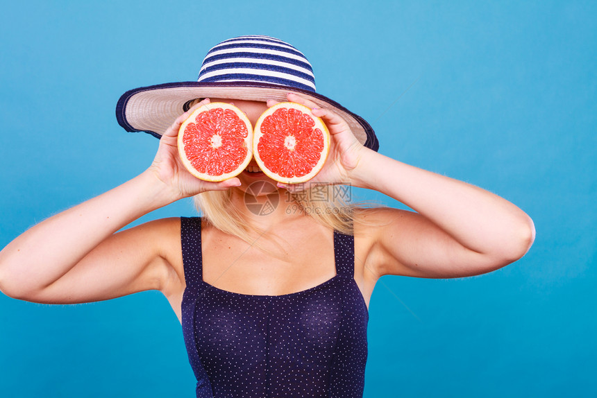 健康饮食新鲜品充满维他命戴太阳帽的妇女拿着甜美味的红葡萄果假装是眼镜拿着红葡萄果像眼镜一样的红葡萄果女人图片