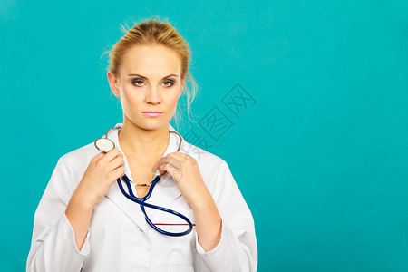 穿白色专业制服的女医生颈部有听诊器青蓝背景图片