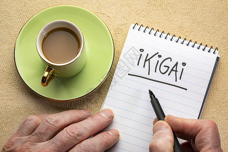 ikigai一个理由男人手写纸条用黑标记在螺旋笔本上背景图片