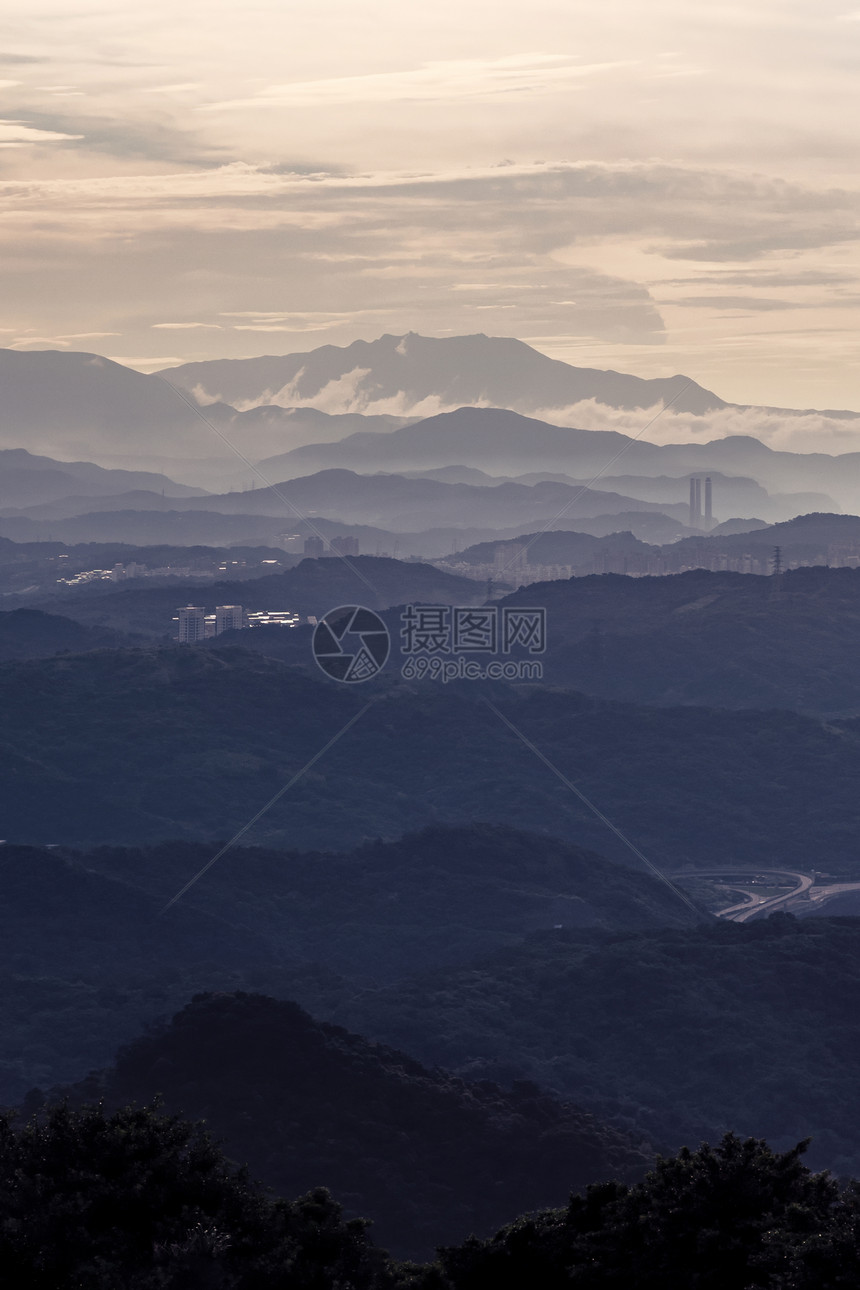 新北市日落时森林树木和山脉带可见的环影有雾和云空自然景观图片