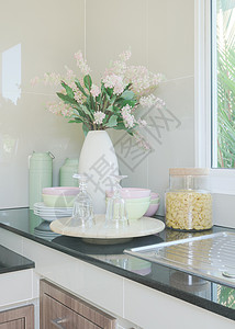 厨房黑柜台顶的陶瓷厨房用具和花瓶图片