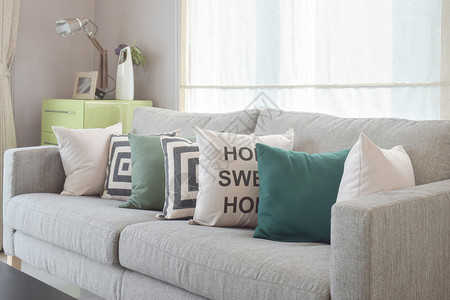 在现代客厅内带有几何型枕头的舒适灰色沙发和几何式枕头图片