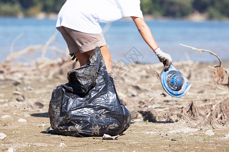 在河岸或湖收集塑料废物图片