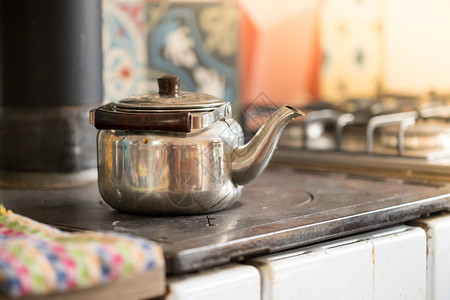 古老烤炉上的金属茶锅图片