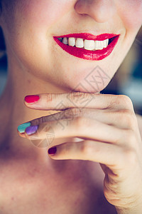 白的漂亮女人带着红色的口和白牙彩色的指甲油正在照镜子图片