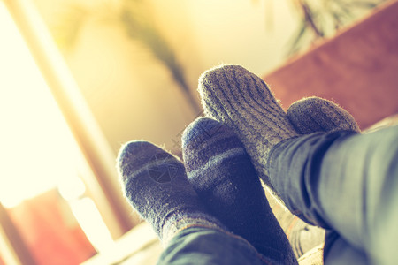 冬季脚和羊绒袜子夫妻在沙发上放松图片