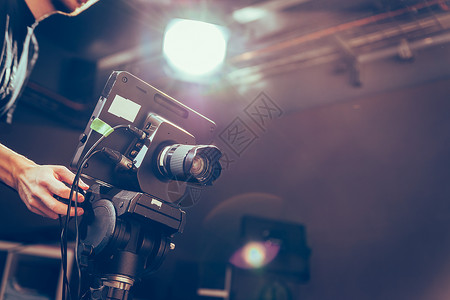 屏摄背景素材男摄影师正在电视演播室操作一部电影摄机背景