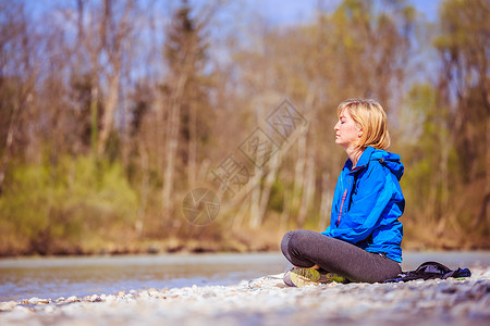 女人坐在石子沙滩上冥想图片