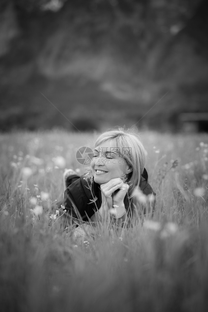 梦幻的金发女孩躺在绿草地上图片