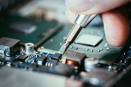 计算机电路板手和螺丝起子技术员正在修一个主机板背景图片