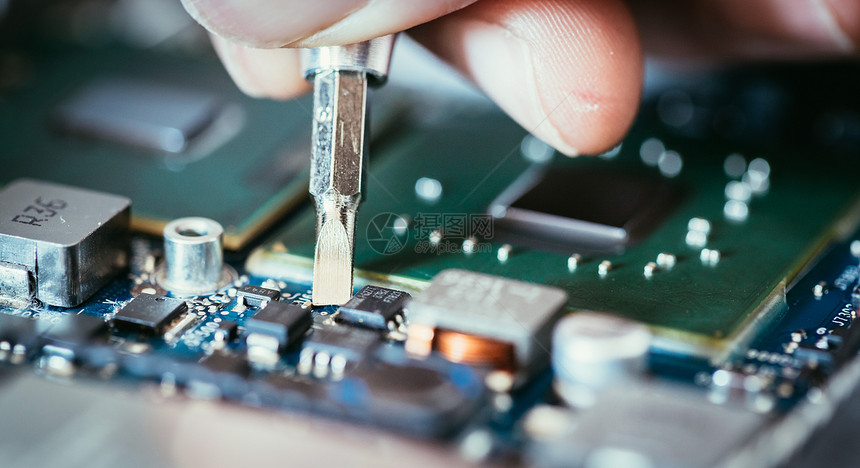 计算机电路板手和螺丝起子技术员正在修一个主机板图片