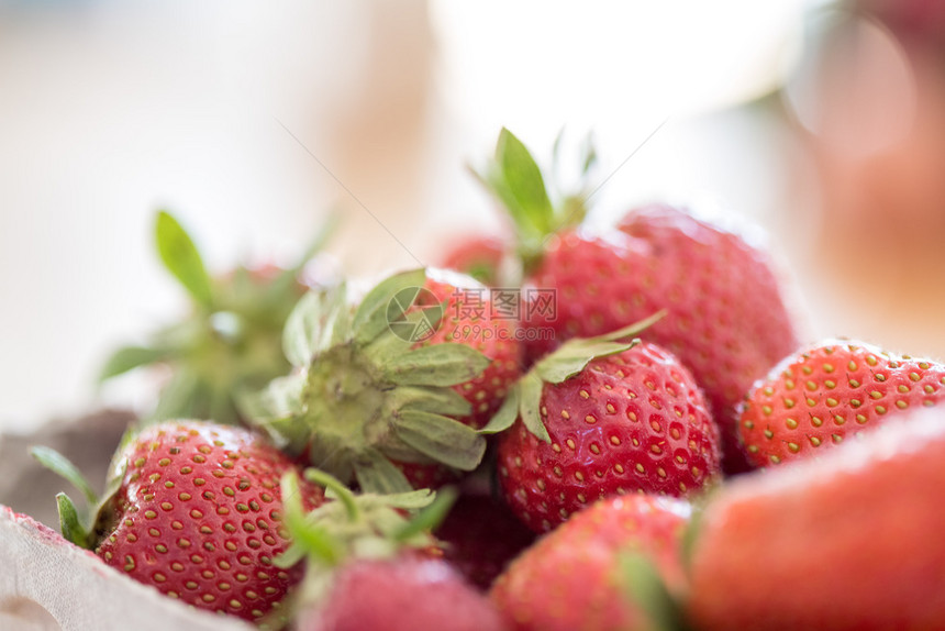 在一个木制桌上的纸板箱里装着新鲜的红有机草莓图片