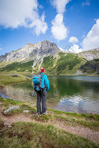 背着包的金色女登山者正在享受风景图片