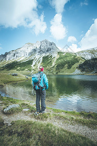 背着包的金色女登山者正在享受风景图片