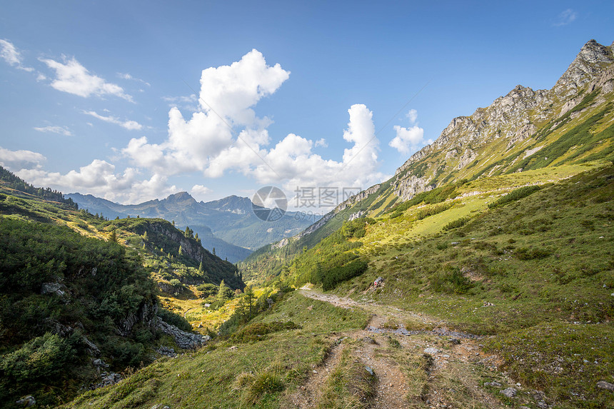 阿尔卑斯山的古景观草地和蓝天空的美丽景色图片