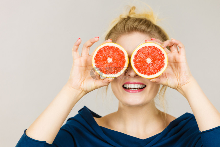 健康饮食新鲜品充满维他命女人拿着甜的柑橘水果葡萄两半假装是眼镜女人拿着水果葡萄半眼睛图片