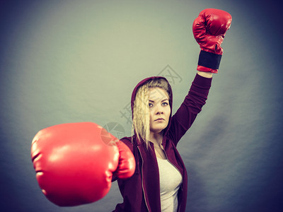 身戴红拳击手套打赢比赛鼓动感到轻松和幸福的运动妇女背景图片