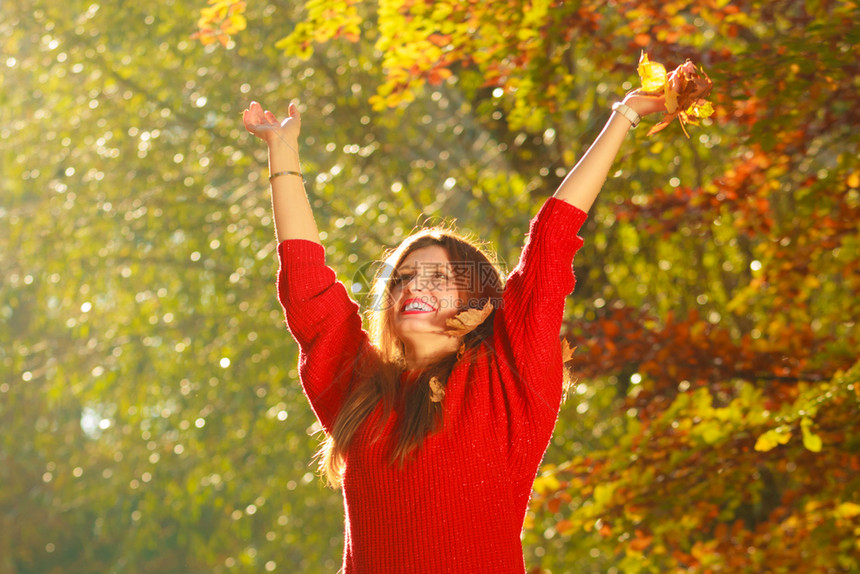 女孩扔树叶秋天森林里的年轻女人玩花叶自然户外放松概念图片