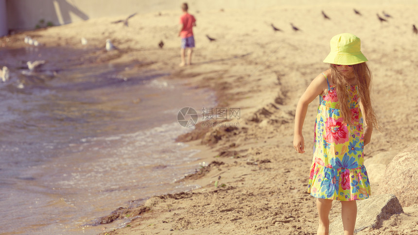 可爱的小女孩穿着暑期服在外面海边玩得开心小孩在海边玩耍图片