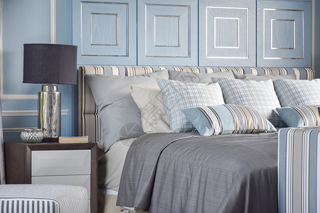 在古典蓝色轻卧室的经典灰色床上用淡蓝的调剥下一个交叉式枕头图片