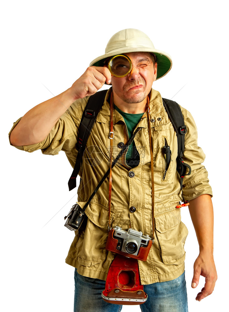 成年游客戴软木头盔和防护服脖子上戴照相机对放大镜中的东西持怀疑态度图片