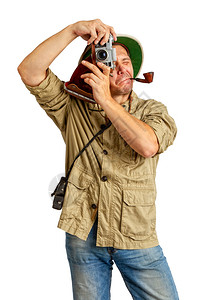 成人旅游者穿着热带软木头盔和防护服嘴里装着管子在旧相机上拍摄一些照片图片