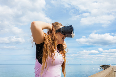 女青年在外测试VR眼镜女青年在夏季天气中佩戴虚拟现实头巾图片