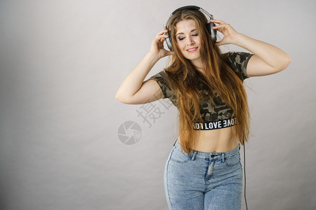 青少年妇女通过大型耳机听音乐玩得开心图片