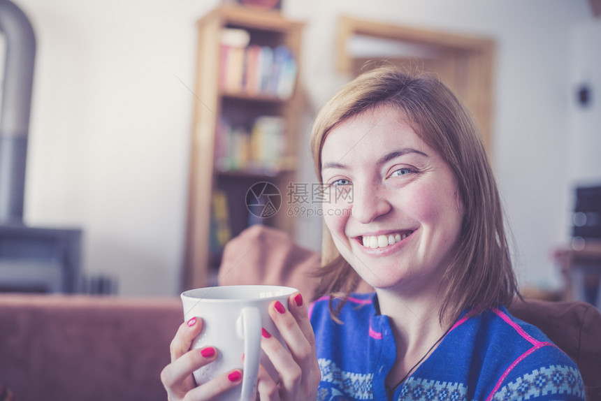 美丽的年轻女士正在享受着一杯茶图片