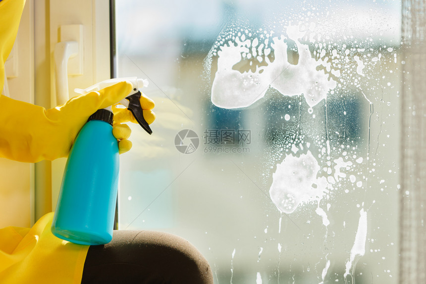 女用黄色手套蓝抹布和喷雾洗涤剂用黄色手套打扫窗户春季清洁家务工作概念使用洗涤剂擦家庭窗户图片