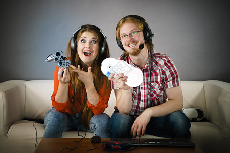 快乐的情侣通过一起玩电子游戏享受休闲时间背景图片