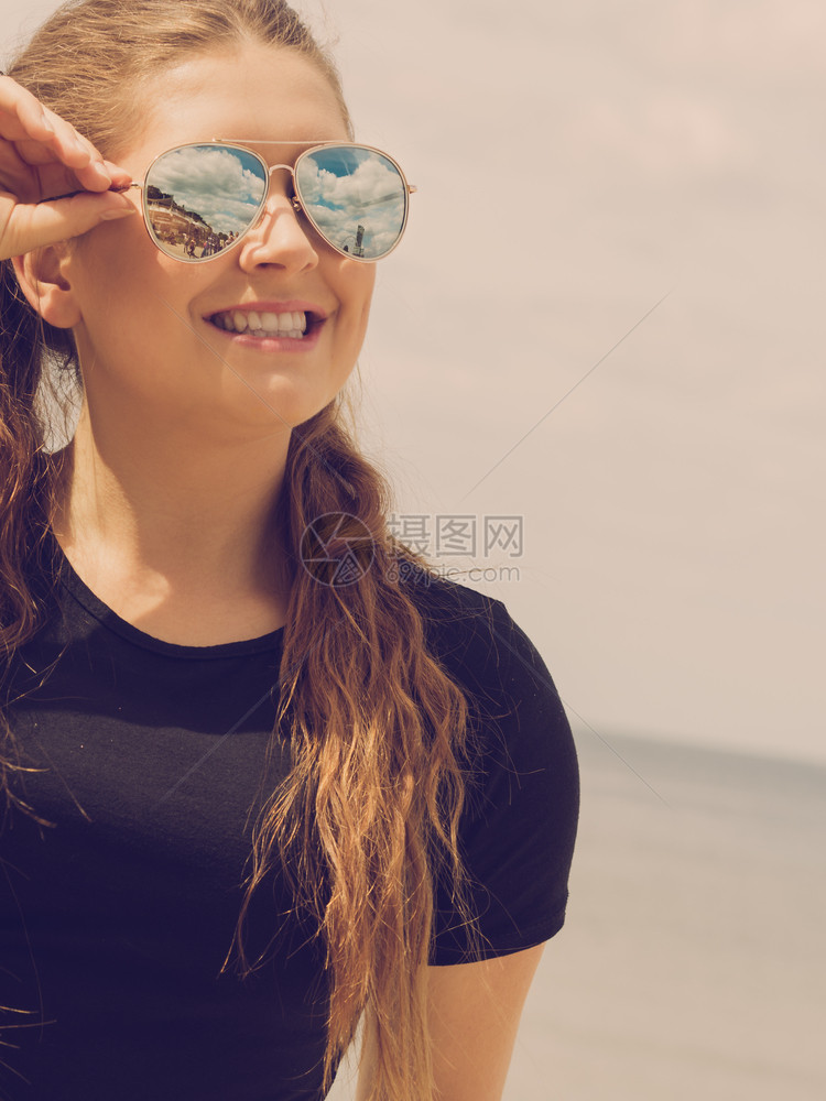 快乐的少女妇享受她的休闲时间长棕发的女子在背景中摆上天空快乐的少女妇对抗云图片