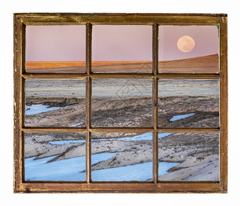 日落和月升在草原上从一个古老的遮光窗看图片