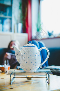 茶壶暖和冬季时间含蓝点的陶瓷茶壶图片