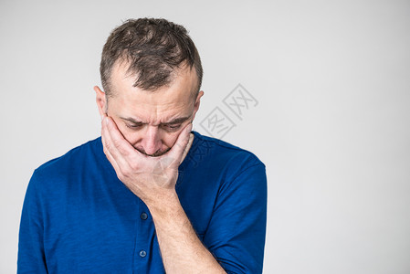 忧郁悲伤焦虑的成年男子蒙住嘴感到内疚和羞愧高清图片